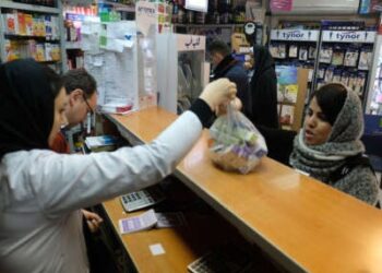 Un farmacéutico entrega una bolsa de medicamentos a un cliente dentro de la farmacia de Sadaf ubicada en la antigua carretera Karaj el 20 de febrero de 2020, en Teherán, Irán. Los iraníes enfrentaron escasez de medicamentos durante la pandemia en medio de sanciones impuestas por los Estados Unidos