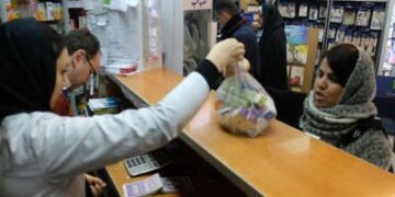 Un farmacéutico entrega una bolsa de medicamentos a un cliente dentro de la farmacia de Sadaf ubicada en la antigua carretera Karaj el 20 de febrero de 2020, en Teherán, Irán. Los iraníes enfrentaron escasez de medicamentos durante la pandemia en medio de sanciones impuestas por los Estados Unidos