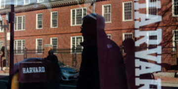 La Universidad de Harvard se refleja en la ventana de una tienda de mercancías al otro lado de la calle de la escuela el 17 de abril de 2025 en Cambridge, Massachusetts.