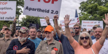 Los sudafricanos blancos tienen una lectura de señalización "Detener el apartheid 2.0" Durante un rally al aire libre
