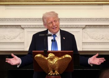 El presidente Donald Trump hablando en un podio.