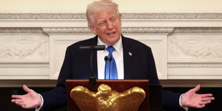 El presidente Donald Trump hablando en un podio.