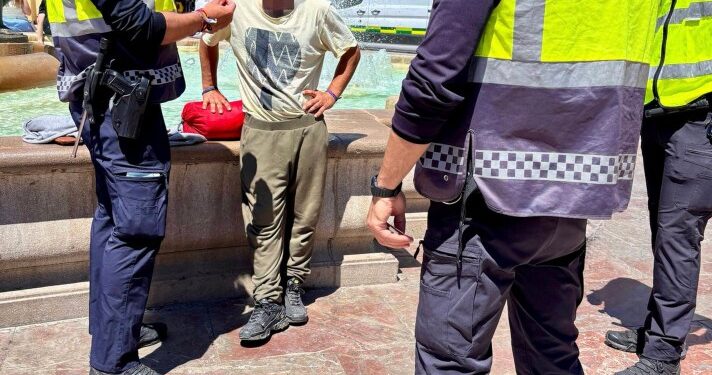 La policía que arresta a un hombre sin hogar en Valencia, España.