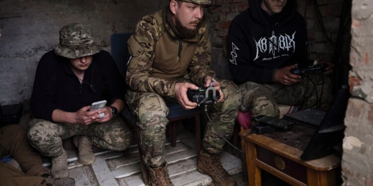 Operadores de drones ucranianos equipos operativos en un puesto de comando improvisado.