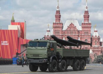 Vehículo blindado que transporta drones en un desfile militar.