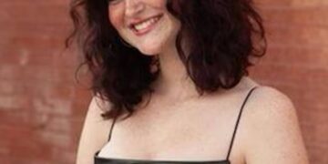 Retrato de una adolescente sonriente con un vestido negro.