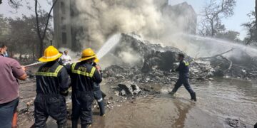 Los trabajadores de rescate extinguiendo un incendio en un lugar de accionamiento en avión.