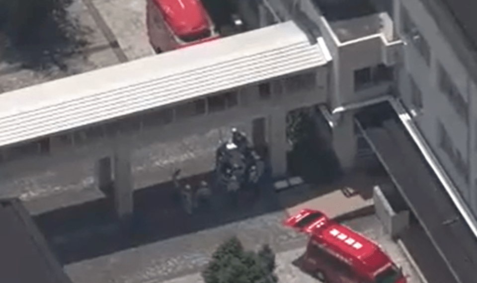 Vista aérea de vehículos de emergencia fuera de una escuela secundaria japonesa.