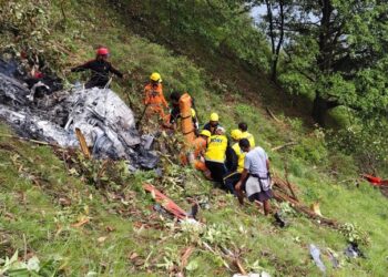 Los trabajadores de rescate en un sitio de accidente de helicóptero.