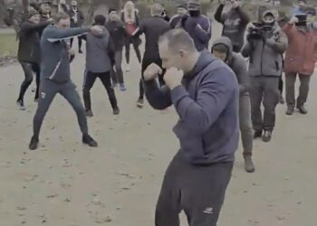 Man Shadow Boxing en un parque con una multitud mirando.
