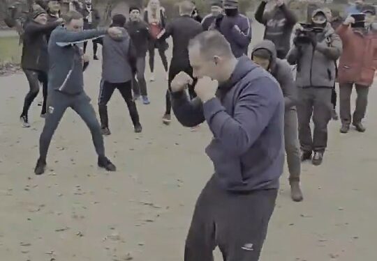 Man Shadow Boxing en un parque con una multitud mirando.