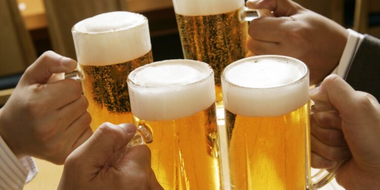 Cuatro personas tostan con cerveza.