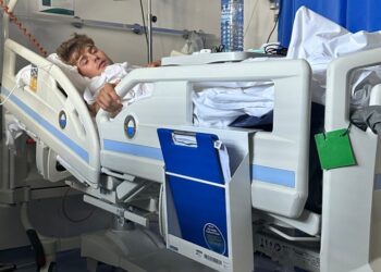 Hombre acostado en una cama de hospital.