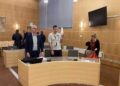 Escena del tribunal con acusados y abogados.