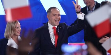 Karol Nawrocki, candidato presidencial polaco, dando una señal de victoria en un evento de la noche de las elecciones.