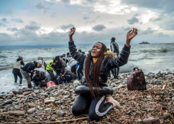 Un migrante del África subsahariana reacciona en una playa en Lesbos, Grecia, después de llegar en barco desde Turquía.
