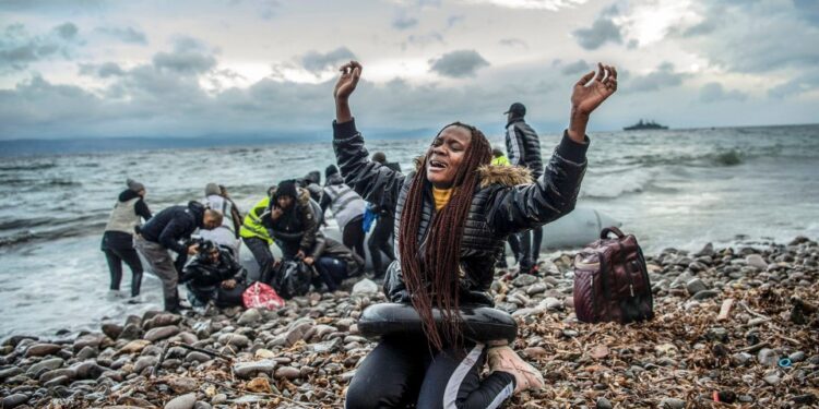 Un migrante del África subsahariana reacciona en una playa en Lesbos, Grecia, después de llegar en barco desde Turquía.