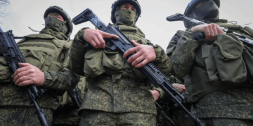 Soldados en uniformes de camuflaje que sostienen rifles.