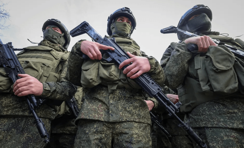 Soldados en uniformes de camuflaje que sostienen rifles.