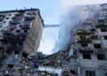 Trabajadores de rescate buscando sobrevivientes en escombros de edificio bombardeado.