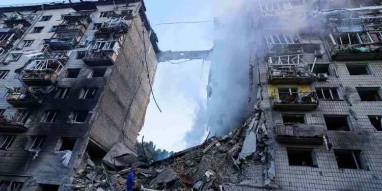 Trabajadores de rescate buscando sobrevivientes en escombros de edificio bombardeado.