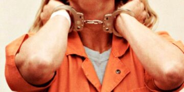 Aileen Wuornos en las esposas, con un mono naranja.