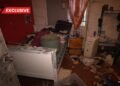 Dormitorio desordenado con pertenencias esparcidas por el piso y la cama.