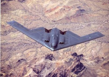 B-2 Bombardero de sigilo espiritual en vuelo sobre el terreno del desierto.