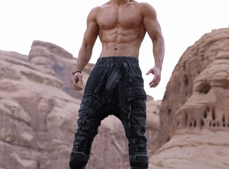 Hombre musculoso de pie sobre una roca.