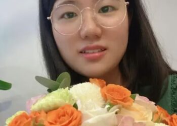 Yunqing Jian sosteniendo un ramo de flores.