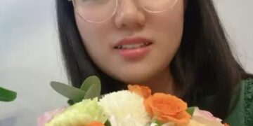 Yunqing Jian sosteniendo un ramo de flores.