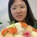 Yunqing Jian sosteniendo un ramo de flores.