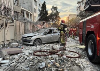 Los primeros respondedores se reúnen fuera de un edificio que fue golpeado por una huelga israelí en Teherán, Irán, el 13 de junio de 2025. (Meghdad Madad/AFP a través de Getty Images)