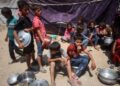 Los niños palestinos hacen cola para alimentos en un punto de distribución en la ciudad de Gaza, el 17 de junio de 2025.
