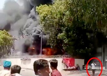 Las imágenes de un hombre se alejan tranquilamente de un gran fuego.