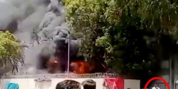 Las imágenes de un hombre se alejan tranquilamente de un gran fuego.