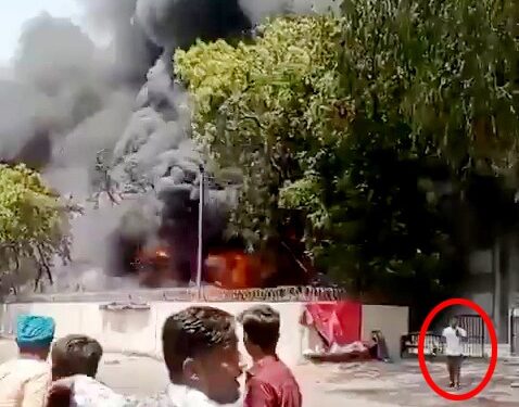 Las imágenes de un hombre se alejan tranquilamente de un gran fuego.