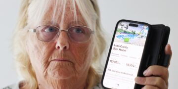 Mujer que muestra la pantalla de su teléfono con una reserva de hotel Corfu.