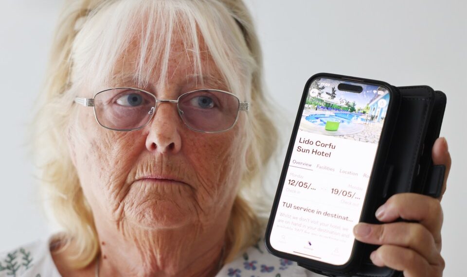 Mujer que muestra la pantalla de su teléfono con una reserva de hotel Corfu.