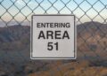 "Entrando el área 51" Firma detrás de una cerca de enlace de cadena.