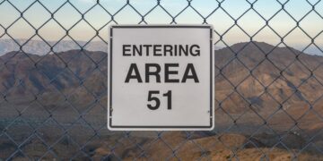 "Entrando el área 51" Firma detrás de una cerca de enlace de cadena.