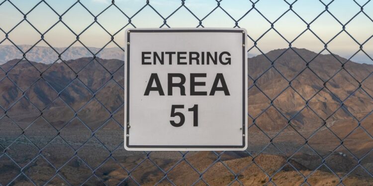 "Entrando el área 51" Firma detrás de una cerca de enlace de cadena.