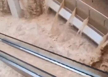 Las aguas de las inundaciones se apresuran a través de un centro comercial, sumergiendo escaleras mecánicas.