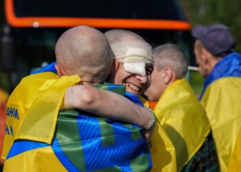 Los prisioneros de guerra ucranianos se abrazan después de un intercambio de prisioneros.