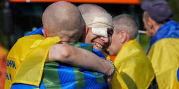 Los prisioneros de guerra ucranianos se abrazan después de un intercambio de prisioneros.