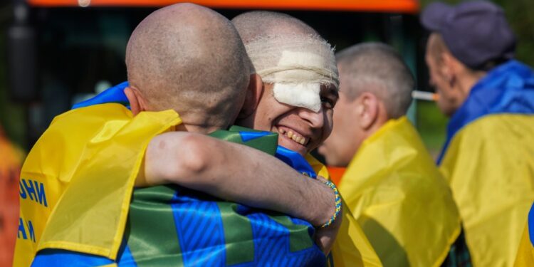 Los prisioneros de guerra ucranianos se abrazan después de un intercambio de prisioneros.
