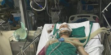 Hombre en soporte vital en una cama de hospital.