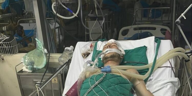 Hombre en soporte vital en una cama de hospital.