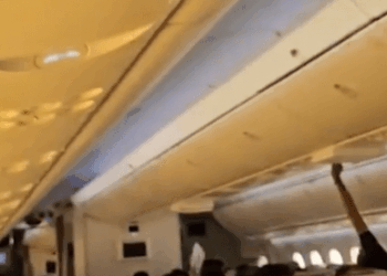 Airplane Passenger Stening Luggage en Binhead Bin.