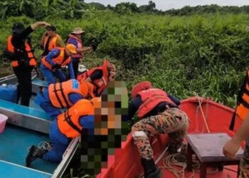 Los trabajadores de rescate recuperando un cuerpo de un río.